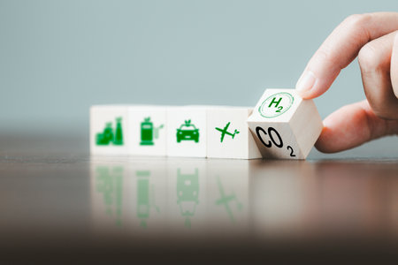 Free Carbon, alternative energy and global climate change concepts. Hand flipping wooden cube blocks with CO2 Carbon dioxide, change to H2 Hydrogen text on table background. Sustainable car energy.の写真素材