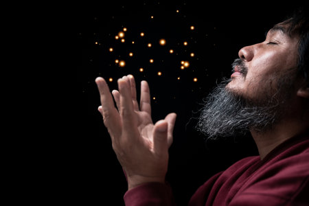 Hands folded in prayer on in church concept for faith, spirituality and religion, man praying in the morning. man hand with praying god. Person Christian men who have faith in Jesus worship in dark.の写真素材