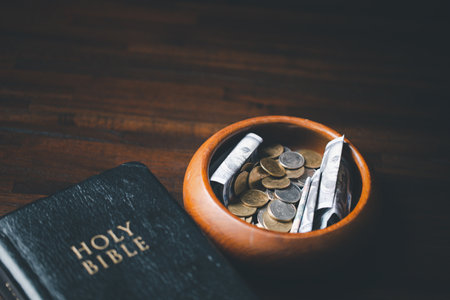 One tenth or tithe is basis on which Bible teaches us to give one tenth of first fruit to God. coins with Holy Bible. Biblical concept of Christian offering, generosity, and giving tithes in church.の写真素材