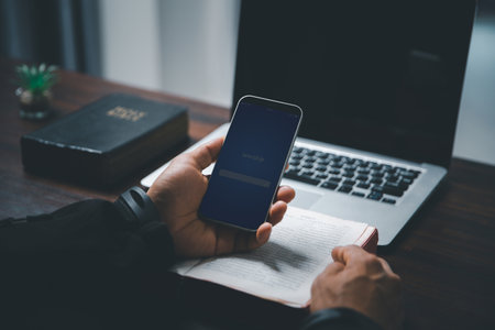 Christian online technology concept. Hands praying of christian with digital computer laptop, Online live church for sunday service. Asian catholic man are reading Holy bible book and online study.の写真素材
