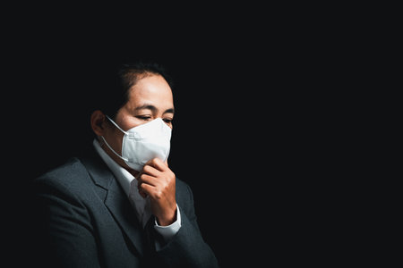 Woman wearing N95 PM 2.5 respiratory protection mask against air pollution and dust particles exceed safety limits. Healthcare, environmental, ecology concept. Allergy, headache. air danger in city.の写真素材