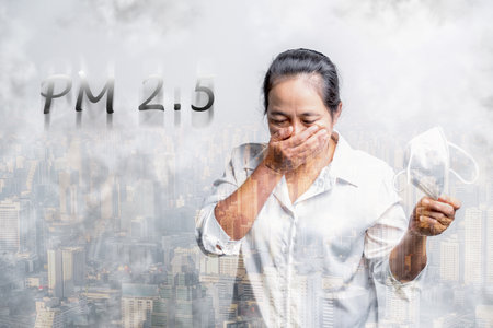 Woman wearing N95 PM 2.5 respiratory protection mask against air pollution and dust particles exceed safety limits. Healthcare, environmental, ecology concept. Allergy, headache. air danger in city.の写真素材