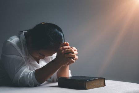 woman kneeling and praying in modern house at sunset time. Female catholic prayer worship to God wish a better life in home at dawn with believe faith. concept of worshipers kneeling.の写真素材