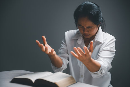 woman kneeling and praying in modern house at sunset time. Female catholic prayer worship to God wish a better life in home at dawn with believe faith. concept of worshipers kneeling.の写真素材