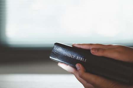 Young woman person hand holding holy bible with study at home. Adult female christian reading book in church. Girl learning religion spirituality with pray to god. concept of student education faith.の写真素材