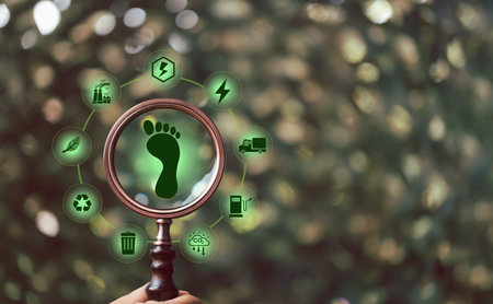 Carbon footprint with magnifying glass on green background. Carbon Footprint is total amount of...