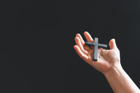 Close up Christian woman hands holding a cross holy and worship. Spirituality and religion Concept, Person holding christian cross to making pray indoors. Believe and faith for christian people.の写真素材