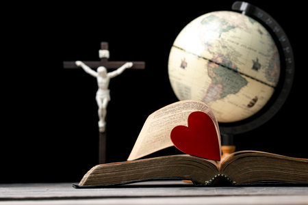 The red heart on holy bible book is the symbol of love from God. The God gives love to all people. We can see or find bible at the church. The bible is the in Christianity religion. Two heart on page.の写真素材