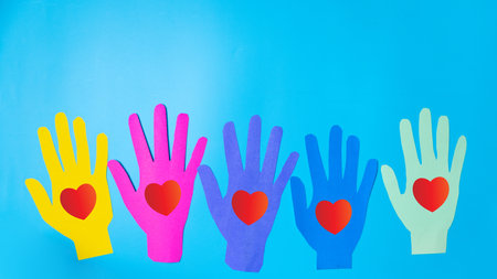 The heart is the symbol of love concept. Valentine day is the day of love or romantic day. All people have heart and love. A small red heart is on the blue, pink and light green hand heart shape.の写真素材