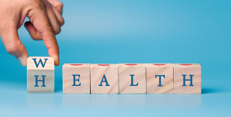 Hand holding wooden block cube which print screen health care and medical icons for healthy and...