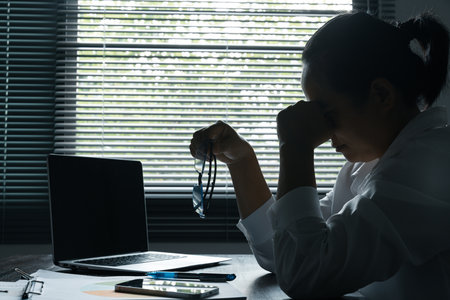 A woman battles depression and stress in her workplace, highlighting the challenges faced by professionals. This image captures the impact of mental health on employees in a corporate environment.の写真素材