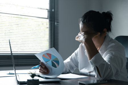 A woman battles depression and stress in her workplace, highlighting the challenges faced by professionals. This image captures the impact of mental health on employees in a corporate environment.の写真素材