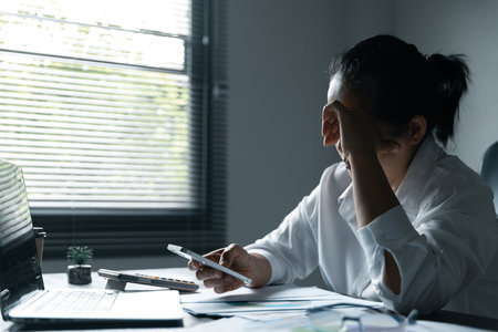 A woman battles depression and stress in her workplace, highlighting the challenges faced by professionals. This image captures the impact of mental health on employees in a corporate environment.の写真素材