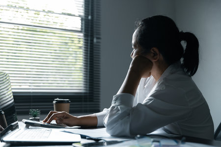 A woman battles depression and stress in her workplace, highlighting the challenges faced by professionals. This image captures the impact of mental health on employees in a corporate environment.の写真素材