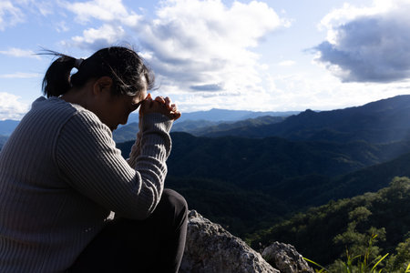 Woman praying and worshiping God on the mountain for a good life.