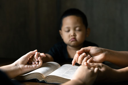 Christian family praying together concept. Child and mother worship God in home. Woman and boy hands...