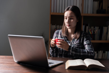 Christian online technology concept. Hands praying of christian with digital computer laptop, Online live church for sunday service. Asian catholic man are reading Holy bible book and online study.の写真素材