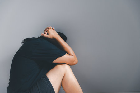 Young depressed woman, domestic and rape violence, beaten and raped sitting in the corner. The concept of sexual harassment against women and rape.の写真素材