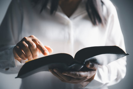 Worship christian with bible concept. Young woman person hand holding holy bible with study at home. Adult female christian reading book in church. Girl learning religion spirituality and pray to god.の写真素材