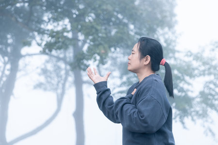 Christian women worship God on a misty morning. Person's hands praying with faith and hope. concept of belief, spirituality, religion.の写真素材