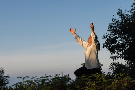 Woman raising his hands in worship. Christian Religion concept. Person on sunlight sky background....