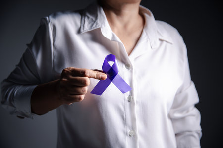 Woman with purple ribbon on grey background, closeup with space for text. Domestic violence awareness. Purple Ribbon for supporting people living. Healthcare and World cancer day concept.の写真素材