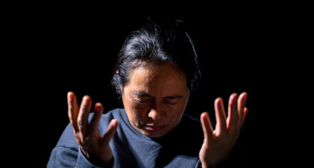 Woman person are praying in dark background. Female christian worship to god in faith. banner, panorama with copy space. Girl christian meditation and pray in christ. Christianity religion concept.の写真素材