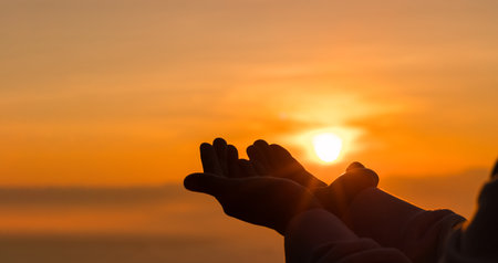 Silhouette of woman kneeling down praying for worship God at sky background. Christians pray to jesus christ for calmness. In morning people got to a quiet place and prayed. copy space.の写真素材