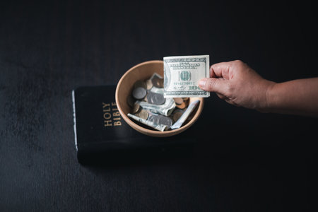 One tenth or tithe is basis on which Bible teaches us to give one tenth of first fruit to God. coins with Holy Bible. Biblical concept of Christian offering, generosity, and giving tithes in church.の写真素材