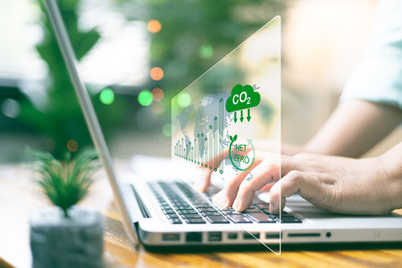 Reduce CO2 emission concept with icons. women using laptop for working technology and business Net zero and carbon neutral. Renewable energy-based green businesses can limit climate change.の写真素材