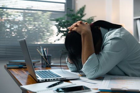 Stress business woman person from hard work, depression in office. Tired and anxious employee female with unhappy at problem job. young businesswoman sitting sad front of laptop computer on desk.の写真素材