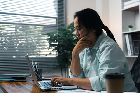 Stress business woman person from hard work, depression in office. Tired and anxious employee female with unhappy at problem job. young businesswoman sitting sad front of laptop computer on desk.の写真素材
