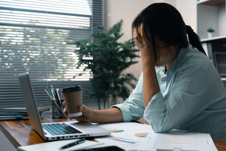 Stress business woman person from hard work, depression in office. Tired and anxious employee female with unhappy at problem job. young businesswoman sitting sad front of laptop computer on desk.の写真素材