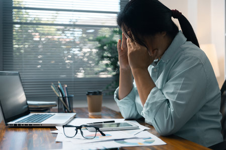 Stress business woman person from hard work, depression in office. Tired and anxious employee female with unhappy at problem job. young businesswoman sitting sad front of laptop computer on desk.の写真素材