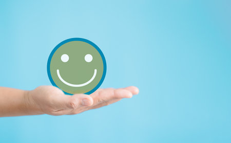 Employee hand holding happy smile face, positive thinking, result mental health assessment, good feedback rating and positive customer review, satisfaction survey, world mental health day conceptの写真素材