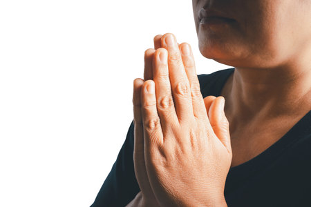 Woman side who believes in god, person hands praying on isolated white background. Asian woman stands in meditative pose, holds hands in praying gesture, has sense of inner peace, Religion concept.の写真素材