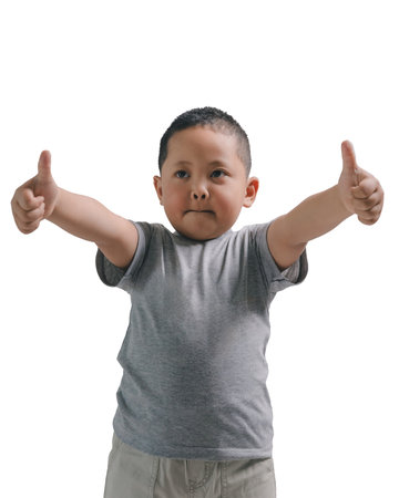 Little boy two thumbs up isolated on white background. Young kid wearing grey shorts and grey t shirtの写真素材