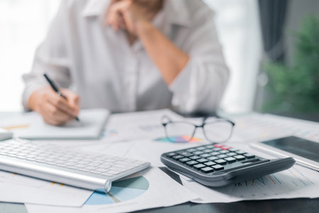 Businesswoman working on desk office with using a calculator to calculate the numbers, finance accounting concept. Woman accountant use calculator and computer. tax, accounting, statisticsの写真素材