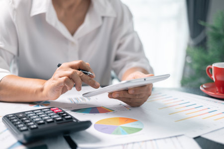 Businesswoman working on desk office with using a calculator to calculate the numbers, finance accounting concept. Woman accountant use calculator and computer. tax, accounting, statisticsの写真素材