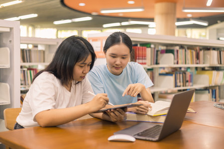 Two young woman, a dedicated student, navigates university life with her friend, embracing education and growth as they pursue their goals together. female student in collegeの写真素材