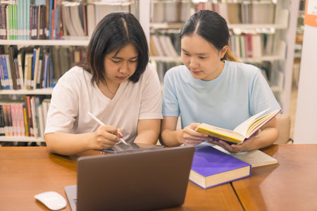 Two young woman, a dedicated student, navigates university life with her friend, embracing education and growth as they pursue their goals together. female student in collegeの写真素材