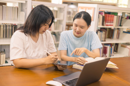 Two young woman, a dedicated student, navigates university life with her friend, embracing education and growth as they pursue their goals together. female student in collegeの写真素材