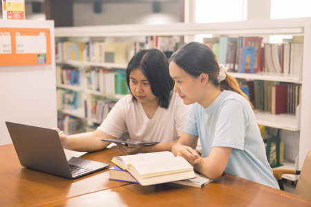 Two young woman, a dedicated student, navigates university life with her friend, embracing education and growth as they pursue their goals together. female student in collegeの写真素材