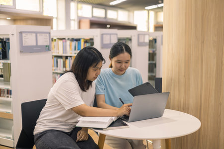 Two young woman, a dedicated student, navigates university life with her friend, embracing education and growth as they pursue their goals together. female student in collegeの写真素材