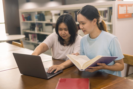 Two young woman, a dedicated student, navigates university life with her friend, embracing education and growth as they pursue their goals together. female student in collegeの写真素材