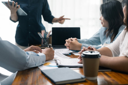 Financial analyst presented a detailed data analysis graph to their colleague, corporate office, demonstrating the business's financial status and trends. Concept of business data analysis.の写真素材