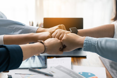 Successful businessman and businesswoman led their professional team in corporate office, where teamwork and collaboration were key to their success, leaving everyone happy after meeting together.の写真素材