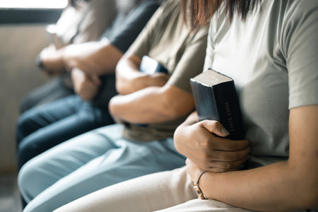 Group of Christian women sat together in chairs, holding their Bibles, feeling the togetherness of...
