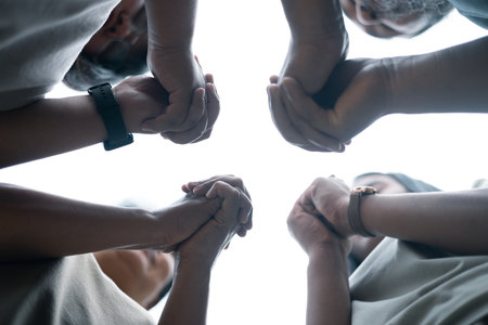 Diverse group came together to pray, support, and help each other, showcasing the strength of community through their diverse backgrounds and unified hands. Group Christian pray concept.の写真素材
