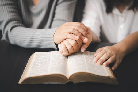 In the church, people to read Bible together, strengthening their faith as devout Catholics united by teachings of holy book. Christians are congregants join hands to pray and seek blessings of God.の写真素材